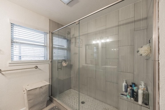 bathroom with a textured ceiling and a shower stall