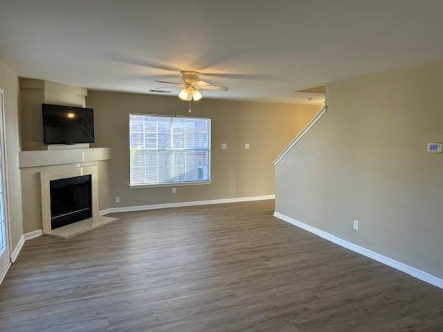 unfurnished living room with dark hardwood / wood-style flooring and ceiling fan