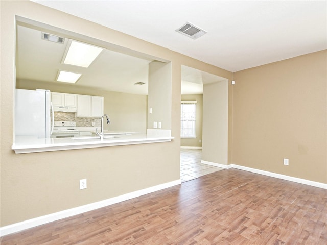 spare room featuring sink and light wood-type flooring