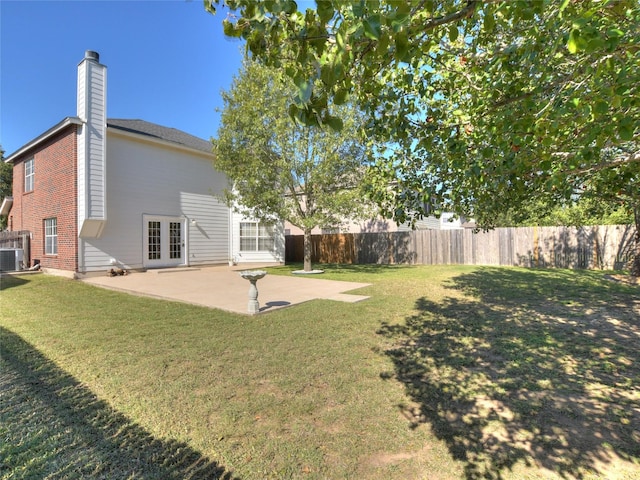 view of yard featuring french doors, central AC, and a patio