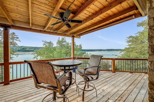 wooden deck with a water view and ceiling fan