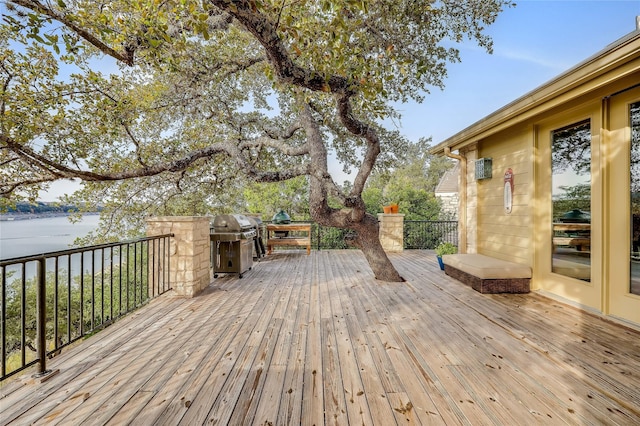 wooden deck featuring area for grilling and a water view