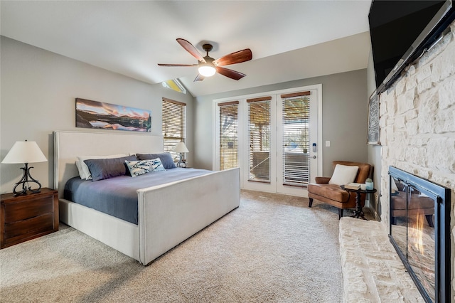 carpeted bedroom with ceiling fan, access to outside, a fireplace, and vaulted ceiling