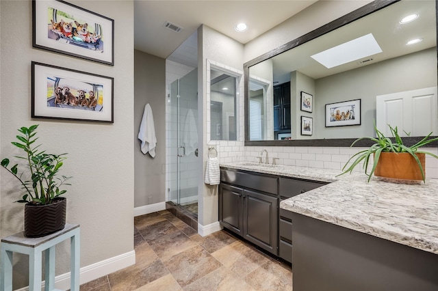 bathroom with walk in shower, vanity, a skylight, and tasteful backsplash