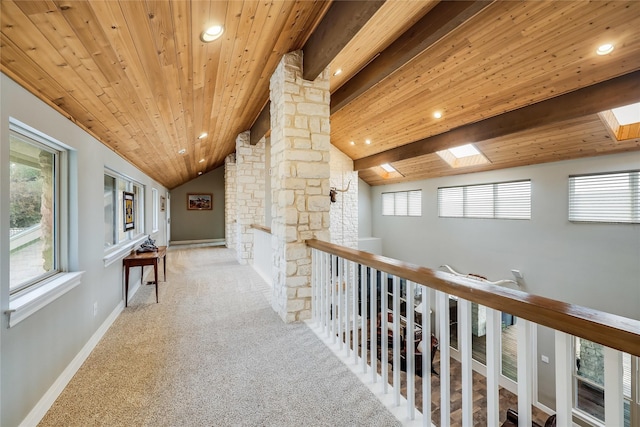 corridor featuring wooden ceiling, a wealth of natural light, and vaulted ceiling with beams