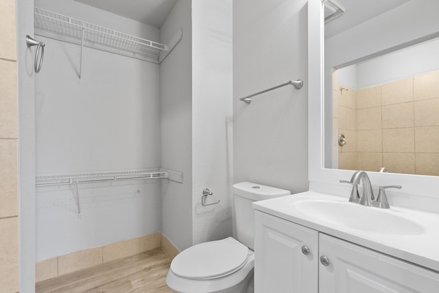 bathroom featuring toilet, hardwood / wood-style flooring, and vanity