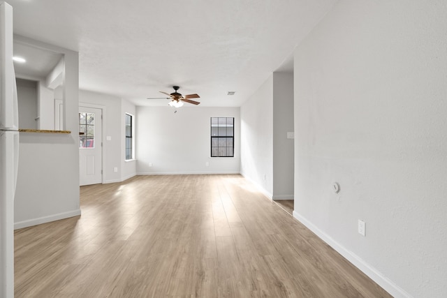 unfurnished living room featuring ceiling fan and light hardwood / wood-style floors