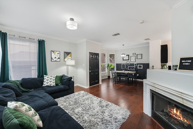 living room with dark wood-type flooring and crown molding