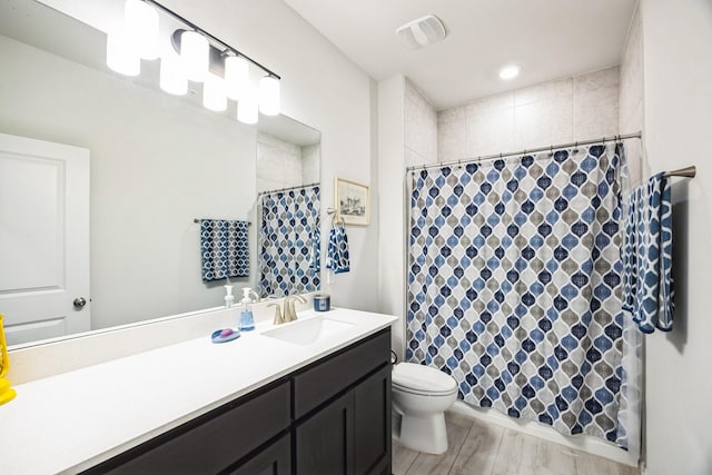 bathroom featuring toilet, vanity, and hardwood / wood-style floors