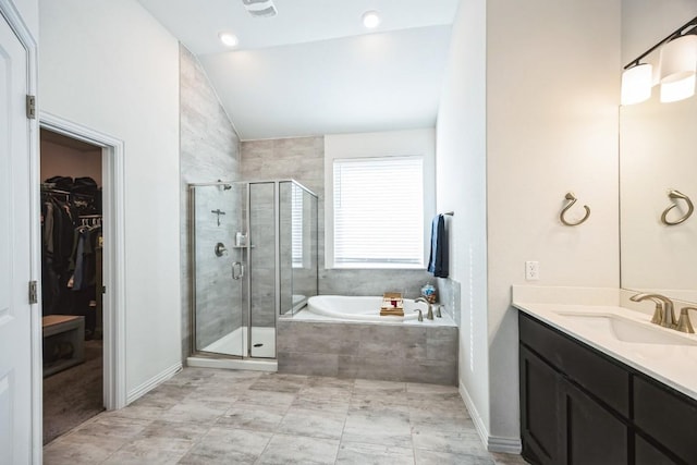 317 Barley Fork Ln, Hutto, TX 78634 - bathroom with a walk in closet, vanity, a shower stall, lofted ceiling, and a garden tub