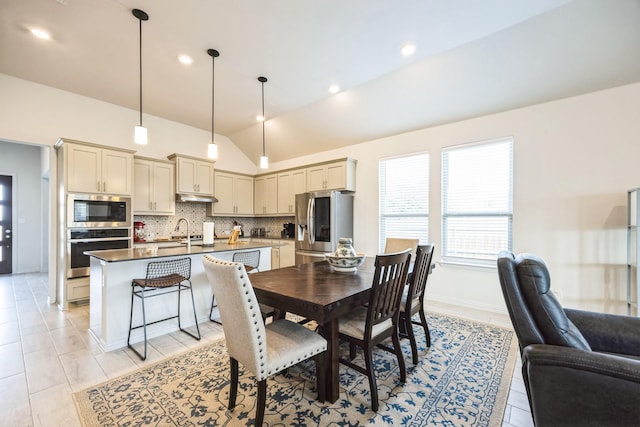 tiled dining area featuring sink and vaulted ceiling