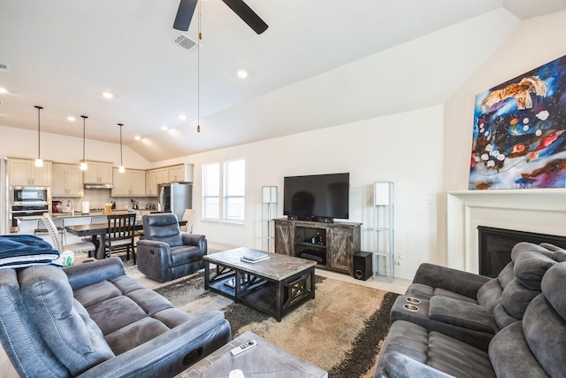 living room with ceiling fan and vaulted ceiling