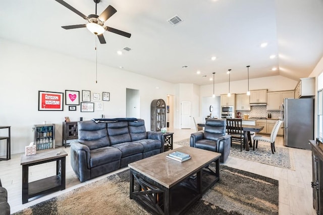 living room with ceiling fan, lofted ceiling, and light wood-type flooring