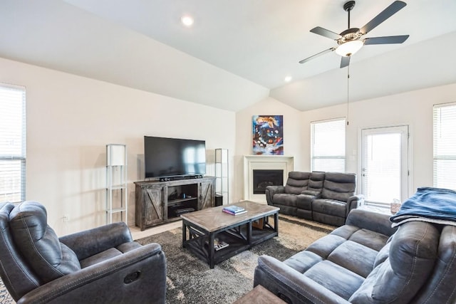 carpeted living room featuring ceiling fan and lofted ceiling