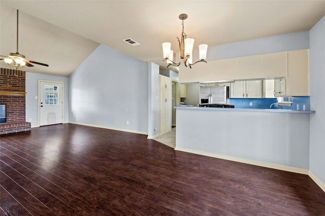 kitchen featuring stainless steel fridge with ice dispenser, hardwood / wood-style flooring, ceiling fan with notable chandelier, and kitchen peninsula