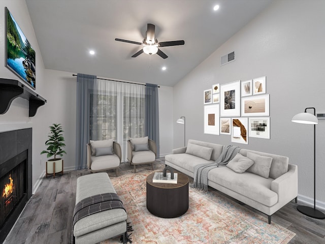 living room featuring lofted ceiling, a fireplace, ceiling fan, and hardwood / wood-style floors