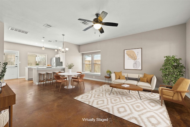 living room with ceiling fan with notable chandelier