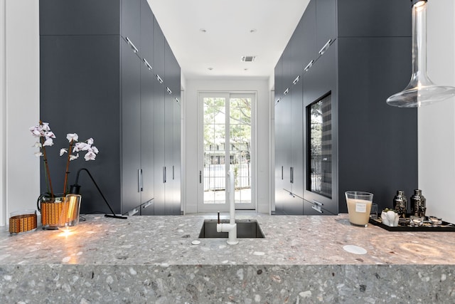 interior space featuring light stone countertops and gray cabinets