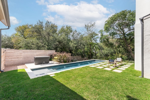 view of swimming pool with a yard