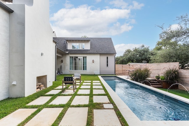 back of property featuring a patio, pool water feature, a fenced in pool, and an outdoor fireplace