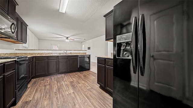 kitchen featuring wood-type flooring, black appliances, ceiling fan, sink, and dark brown cabinets