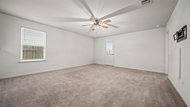 empty room featuring ceiling fan and carpet