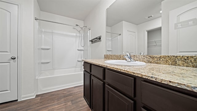 bathroom featuring  shower combination, vanity, and hardwood / wood-style flooring