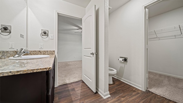 bathroom with toilet, vanity, and hardwood / wood-style floors