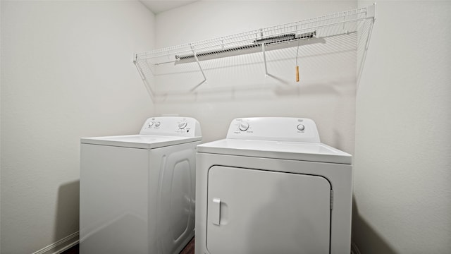 clothes washing area with washing machine and dryer