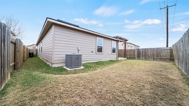 back of house featuring a lawn and central AC unit