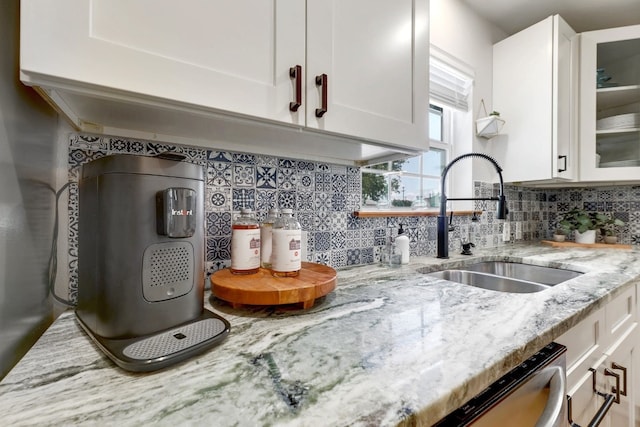 407 S Pine St, Georgetown, TX 78626 - kitchen featuring white cabinetry, a sink, decorative backsplash, and glass insert cabinets
