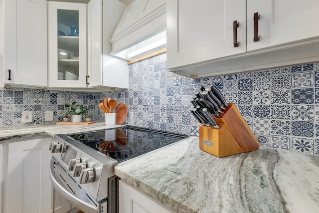 407 S Pine St, Georgetown, TX 78626 - kitchen with stainless steel electric stove, premium range hood, white cabinets, and glass insert cabinets
