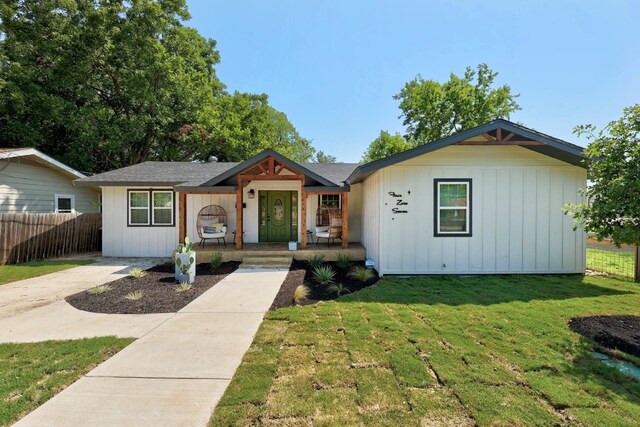 ranch-style house with a porch and a front yard