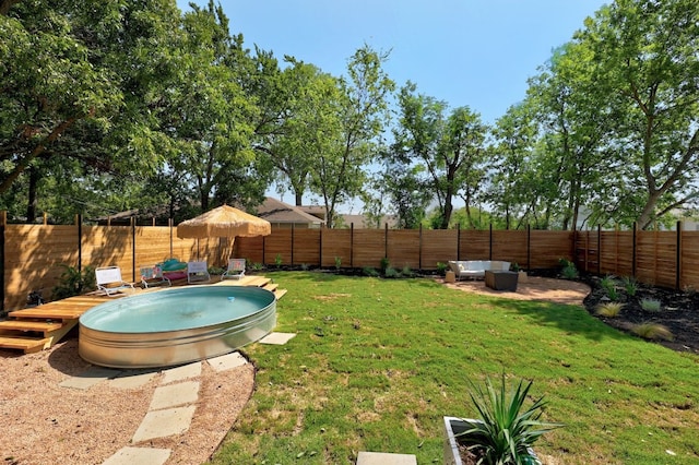 view of yard with an outdoor living space and a swimming pool side deck