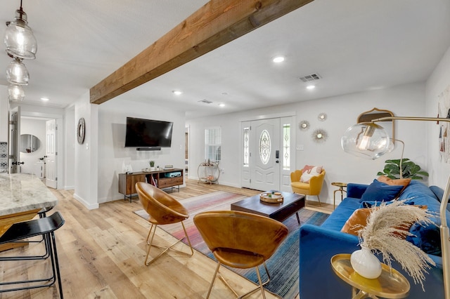 living room with light hardwood / wood-style floors and beamed ceiling