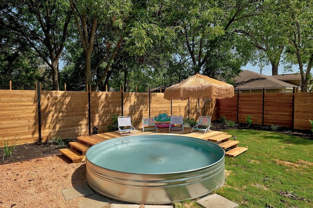 view of swimming pool with a yard and a deck