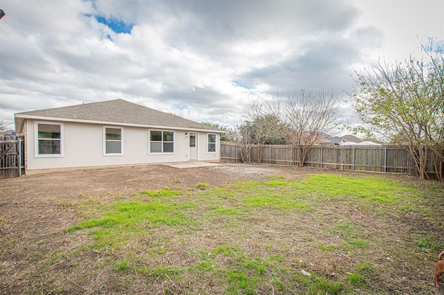 rear view of property with a yard and a patio area