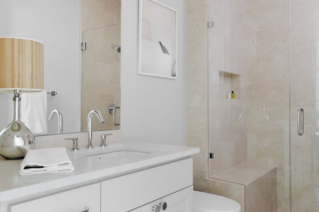 bathroom featuring toilet, a shower with door, and vanity