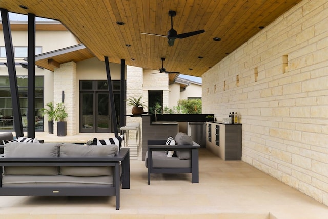 view of patio with an outdoor kitchen, a bar, ceiling fan, and an outdoor hangout area