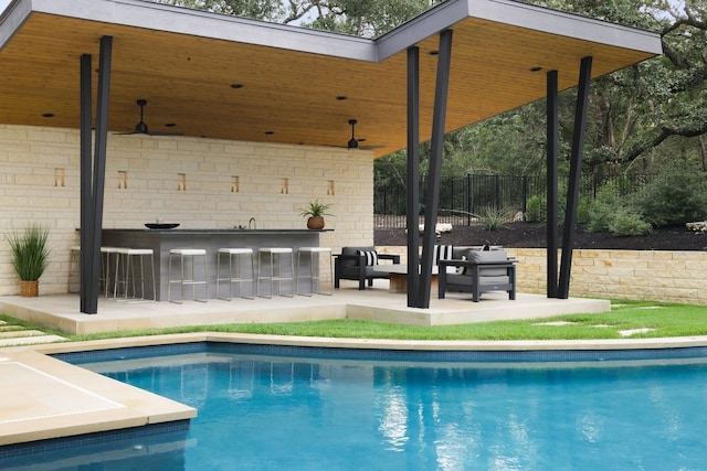 view of pool featuring exterior bar, an outdoor hangout area, and a patio