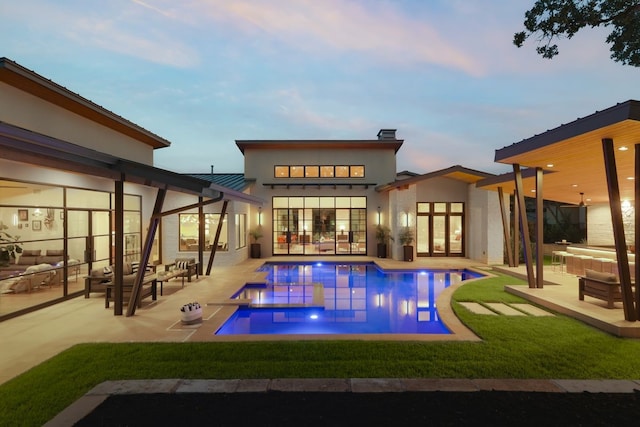 back house at dusk with a patio and an outdoor hangout area