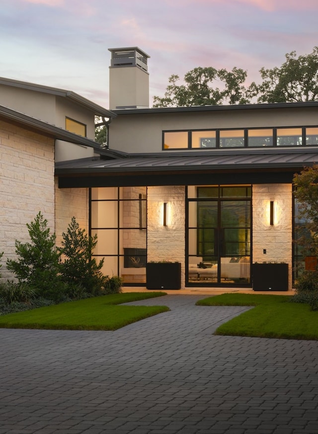 back house at dusk with a lawn