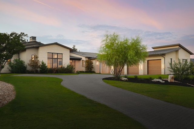 view of front of property featuring a lawn and a garage