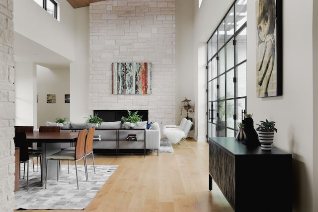 living room featuring a towering ceiling and light hardwood / wood-style flooring