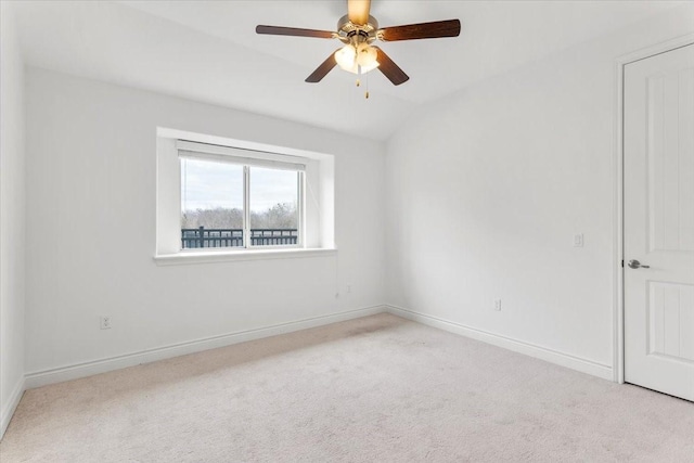 carpeted empty room featuring ceiling fan and vaulted ceiling