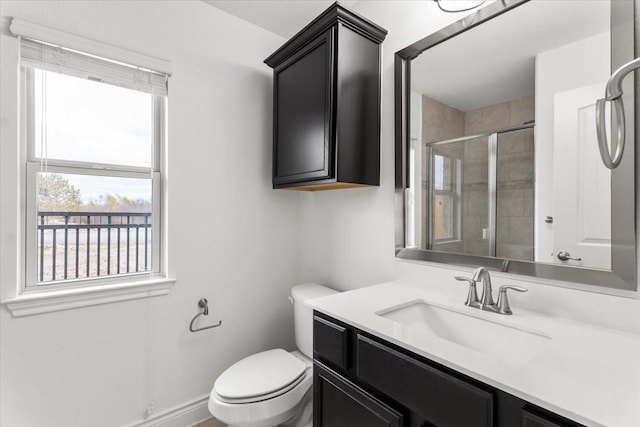 bathroom with an enclosed shower, vanity, and toilet