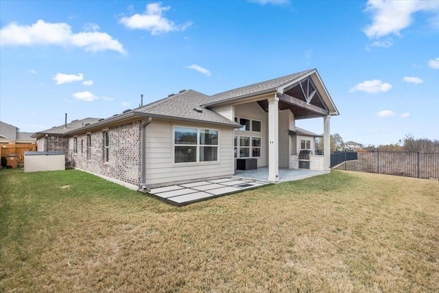 back of property with a lawn and a patio area