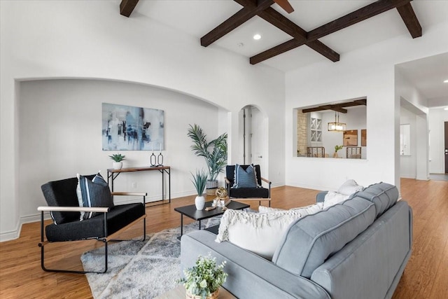 living room featuring coffered ceiling, hardwood / wood-style flooring, and beamed ceiling