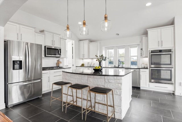 kitchen with stainless steel appliances, sink, decorative light fixtures, white cabinetry, and decorative backsplash