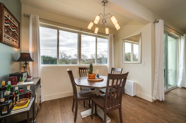 dining space with dark wood-type flooring and a chandelier